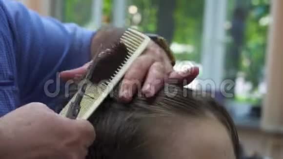 在理发店的男孩可爱的男孩在美发沙龙理发发型用机器剪发视频的预览图