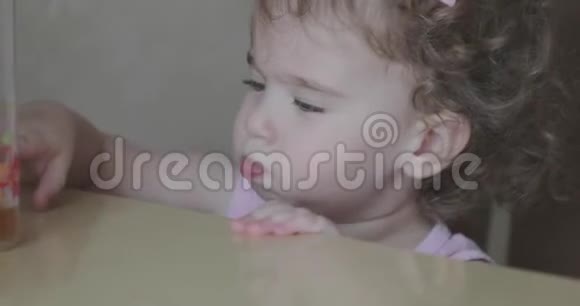 小卷曲女孩在吃吸管面包店视频的预览图
