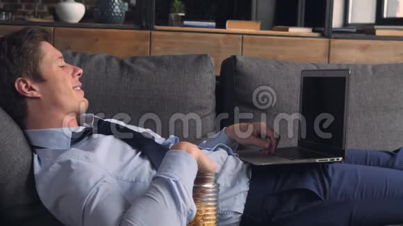 一个在公寓里用电脑和饭放松的家伙视频的预览图
