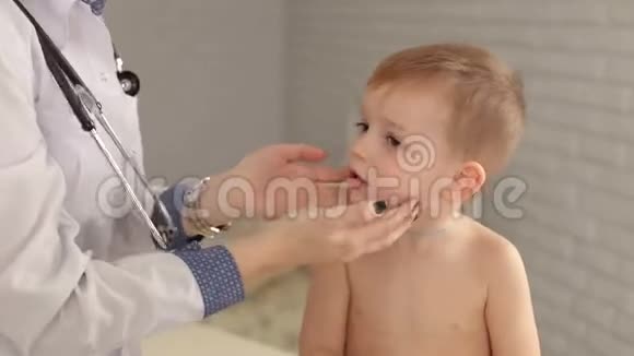 医生在医院检查一个生病的孩子的喉咙视频的预览图