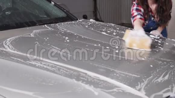 年轻女子用海绵洗车视频的预览图