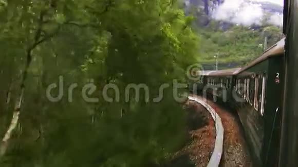 绿色火车在山林中行驶山丘绿色植物夏日景观大自然视频的预览图