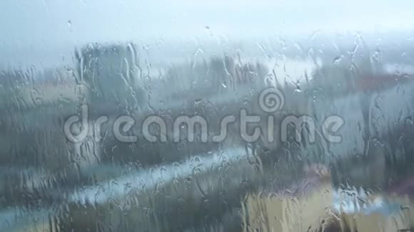 雨滴滴落的窗户背景模糊的城市特写视频的预览图