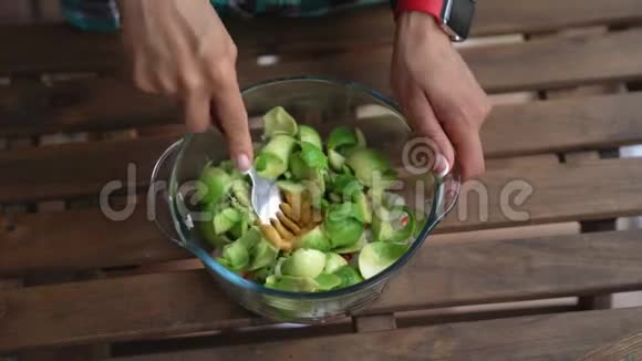 在家庭厨房的餐桌上用女性手混合鳄梨酱产品视频的预览图
