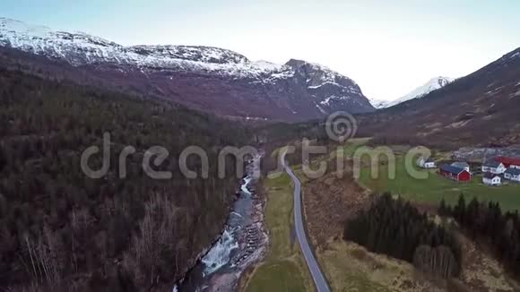 挪威景观的空中景观有洪水泛滥的河流山顶上有雪的沼泽和绿色的田野视频的预览图