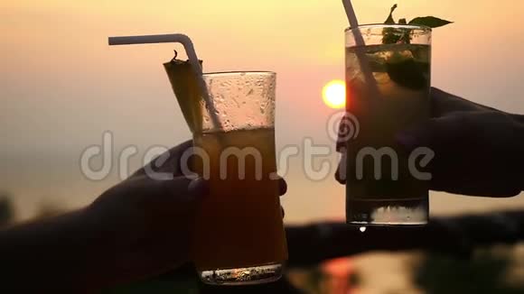 亲密无间的情侣们在山上的咖啡馆里喝着美味的鸡尾酒俯瞰大海和令人惊叹的日落视频的预览图