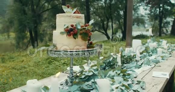 移动相机从美丽可口的婚礼蛋糕在桌子上装饰着可爱的蜡烛花和叶子视频的预览图