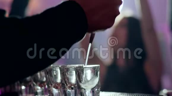 酒吧柜台的小玻璃杯里倒了一杯酒精鸡尾酒视频的预览图