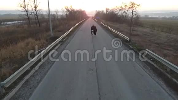 一对夫妇在去城市的路上散步空中射击视频的预览图