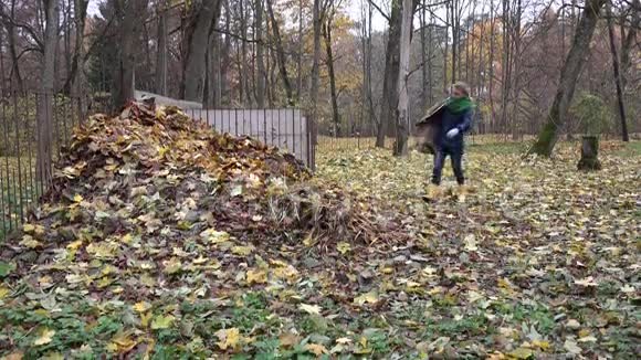 女人把秋天的叶子从袋子里扔进堆堆肥里4K视频的预览图