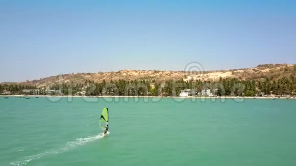冲浪者接近海滩白色酒店综合体视频的预览图