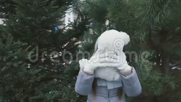 小女孩玩长毛绒熊并把它扔到杉树背景视频的预览图