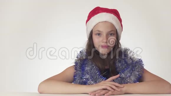 圣诞老人戴着圣诞老人的帽子戴着新年礼物漂亮的少女坐着梦见一件礼物视频的预览图