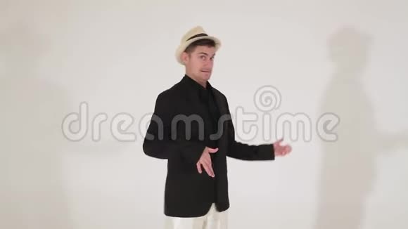 戴着帽子和黑色西装的可爱的家伙正在模仿弹吉他和在镜头上跳舞视频的预览图