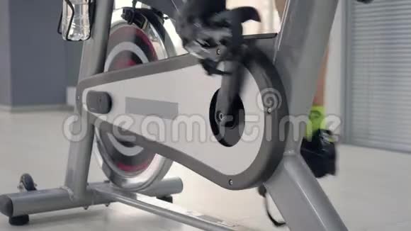 女人的腿在旋转自行车上旋转踏板视频的预览图