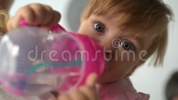可爱的婴儿在有爱心的母亲手中饮水视频的预览图