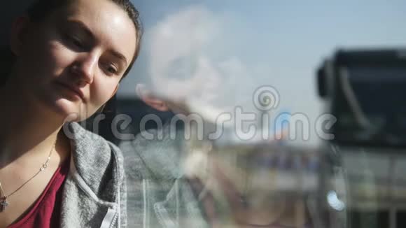 疲惫而悲伤的女孩坐在靠近窗户的地方在机场候机楼等着她的飞机关门视频的预览图