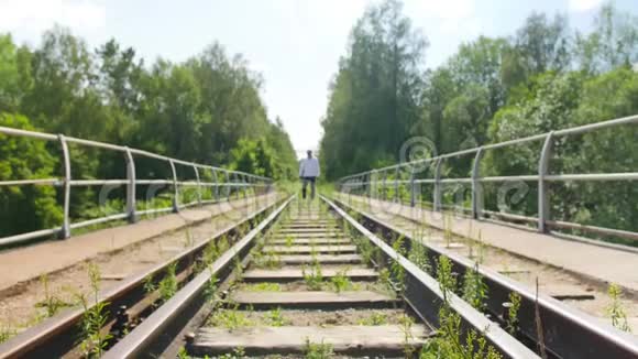 一个从远处走在废弃的铁路桥上的人全垒打视频的预览图