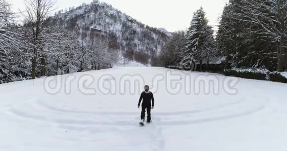 冬天在松林林附近的雪覆盖的田野上人们背着雪鞋散步欧洲阿尔卑斯山视频的预览图