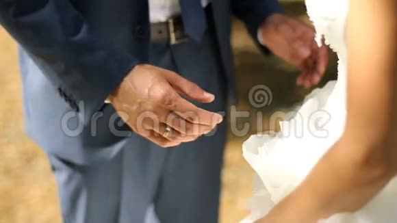 不知名的新婚夫妇新娘穿着长长的婚纱来到新郎身边温柔地拥抱他视频的预览图
