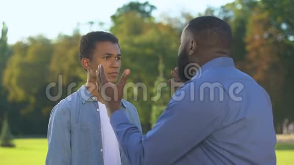 美国父亲和十几岁的儿子在户外争吵家庭冲突交流视频的预览图