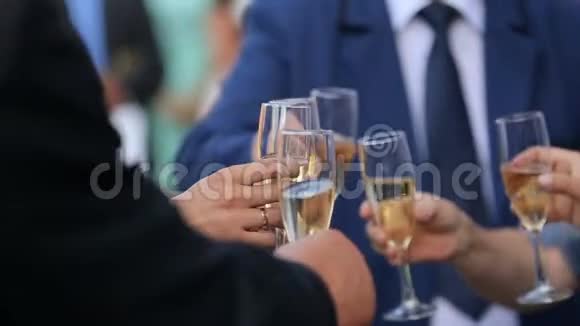 婚礼客人的近景与香槟碰撞的眼镜敬酒的概念没有脸视频的预览图