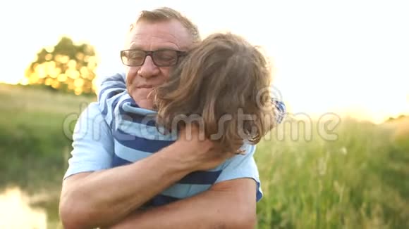 爷爷抱孙子的特写镜头那个卷发男孩求助于他的祖父工作的连续性视频的预览图