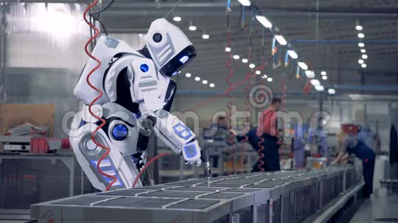 人类喜欢的机器人在工厂工作使用一种特殊的工具视频的预览图