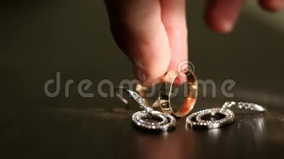不知名的男性手把新娘的金婚戒指放在新郎的旁边由戒指组成的婚礼构图视频的预览图