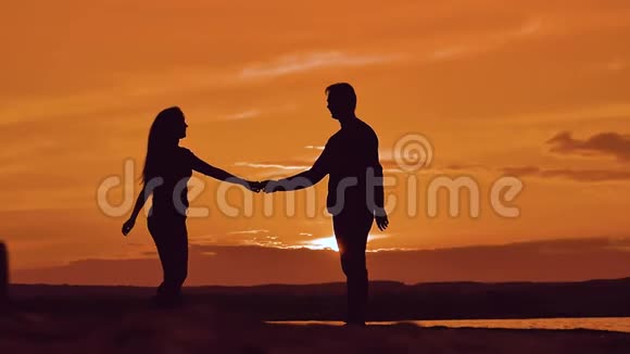 男人和女人纺手剪影男人和女孩幸福的年轻夫妇在外面慢舞视频的预览图