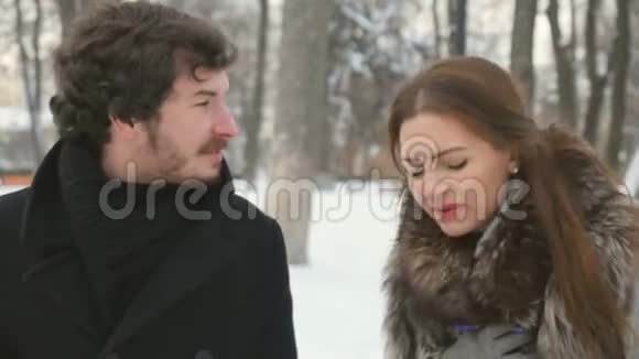 美丽的女人和可爱的男人在下雪的冬季公园争吵视频的预览图