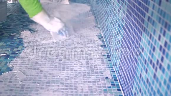 在游泳池里放赋格的工人瓷砖灌浆视频的预览图