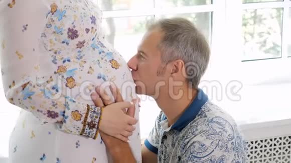 男人亲吻孕妇的腹部视频的预览图