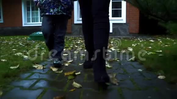 秋日年轻的妈妈和儿子一起走在小路上视频的预览图
