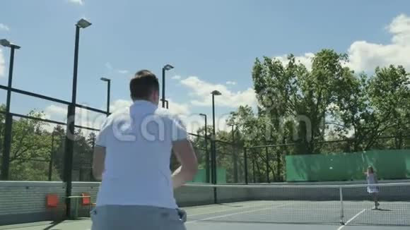 两个年轻朋友在户外的网球场打网球视频的预览图
