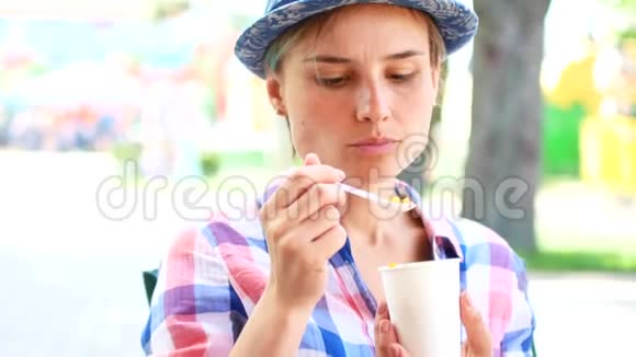 女性在夏季公园吃街头美食玉米旅游美食理念视频的预览图