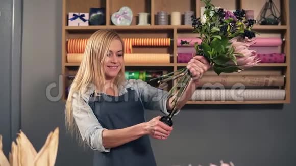 专业女花艺师在花店准备花束花匠切花茎的慢镜头视频的预览图