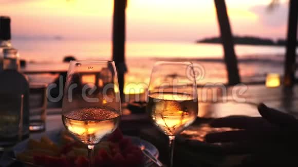 夫妻俩手里拿着两杯白葡萄酒对着大海的夕阳慢动作1920x1080视频的预览图
