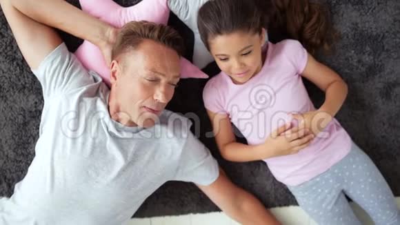 一个和女儿一起休息的英俊男子的俯视图视频的预览图