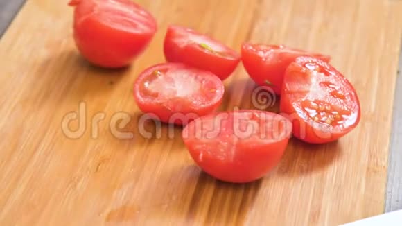 女性手拿刀的特写是在木切割板上切西红柿做沙拉家庭厨房视频的预览图