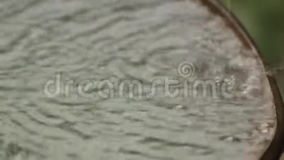 雨水流入一个生锈的旧桶雨滴特写视频的预览图