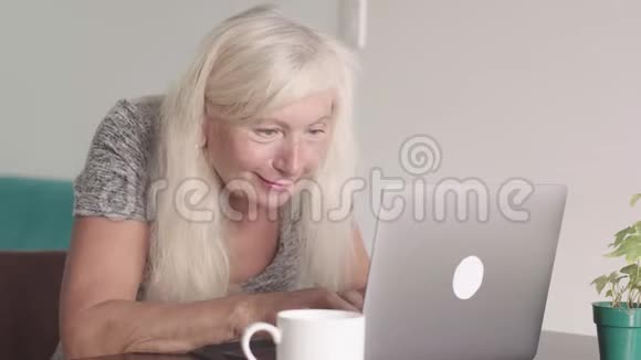 离退休老奶奶在家客厅用笔记本电脑特写镜头快乐的老年商业女性视频的预览图