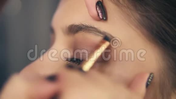 专业化妆时的眉毛护理一位年轻女性的特写镜头她的眉毛用眉毛刷和阴影塑造视频的预览图
