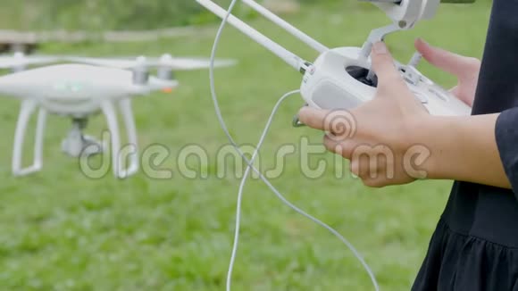 女性的手控制无人机与发射机遥控器视频的预览图