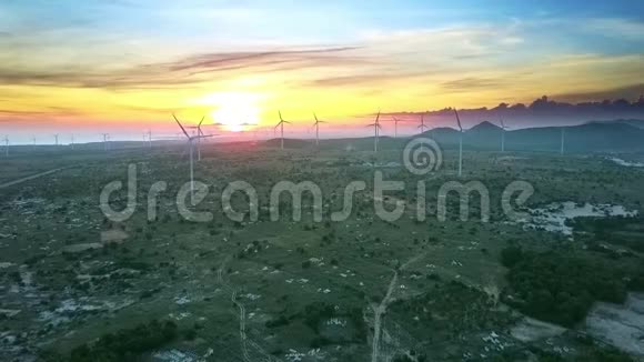 在橘色日落鸟瞰带风力涡轮机的山谷视频的预览图
