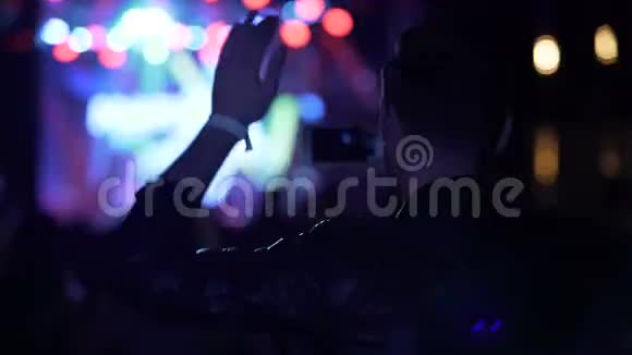 年轻男性在音乐会上挥舞双手并用手机拍摄视频视频的预览图