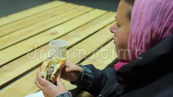 无家可归者收容所女人吃汉堡喝茶不健康食品视频的预览图