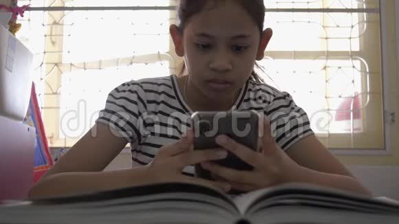 可爱的亚洲女孩使用和观看在线视频从智能手机视频的预览图