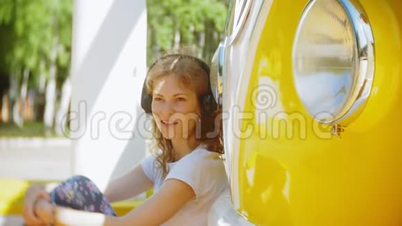 年轻女性在户外乘坐黄色车用智能手机耳机听音乐放松享受概念视频的预览图
