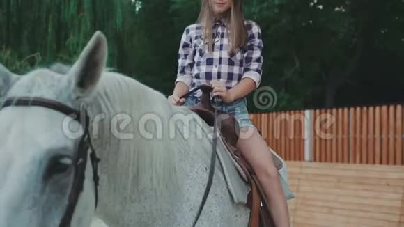 坐在马背上对着镜头微笑的漂亮女孩视频的预览图